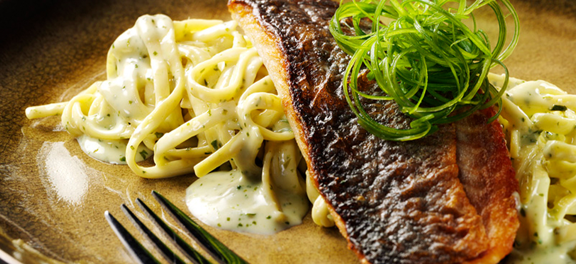 Loup de mer cuit sur peau, spaghetti et sauce au fromage-pesto