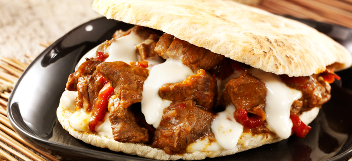 Pain pita au ragoût de viande, poivrons grillés et brie