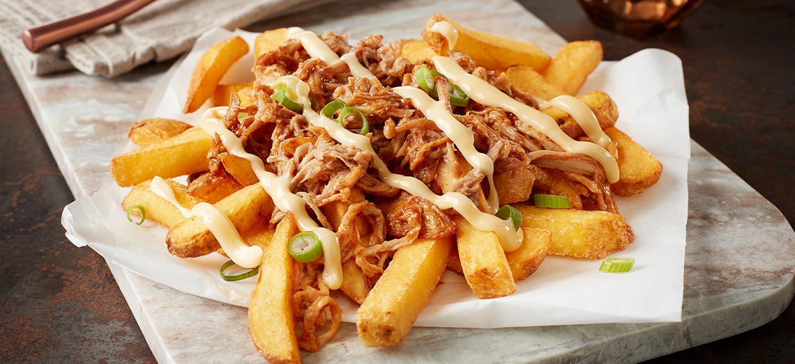 Dick geschnittene Pommes frites mit Pulled Pork und Gouda