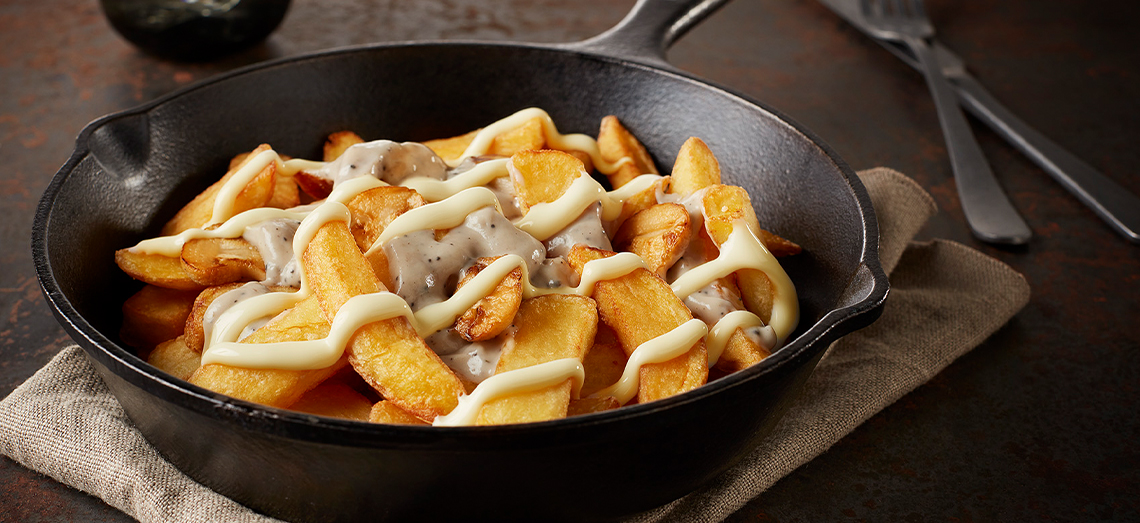 Pommes frites mit Champignonragout und Parmesankäse