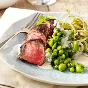 Zartes Beefsteak mit grüner Pasta und einer Soße aus Ziegenkäse