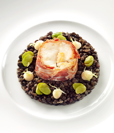 Fried catfish fillet with black lentils and a goat’s cheese topping