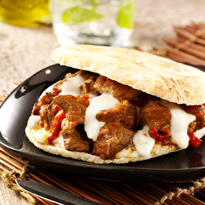 Pita sandwich with stewed meat, roast pepper and melted brie