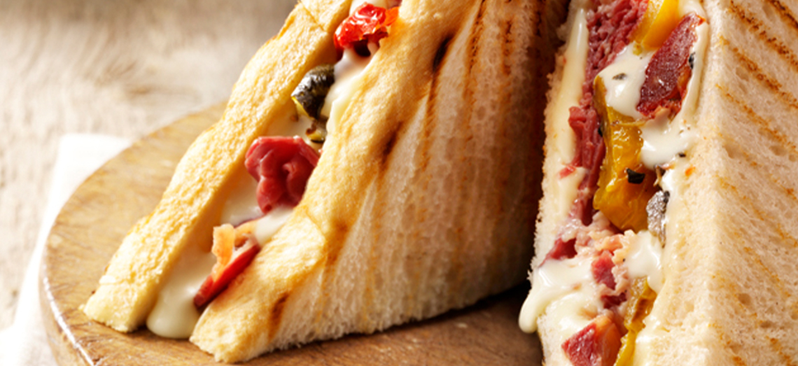 Toasted sandwich with pastrami, grilled vegetables and extra aged cheese