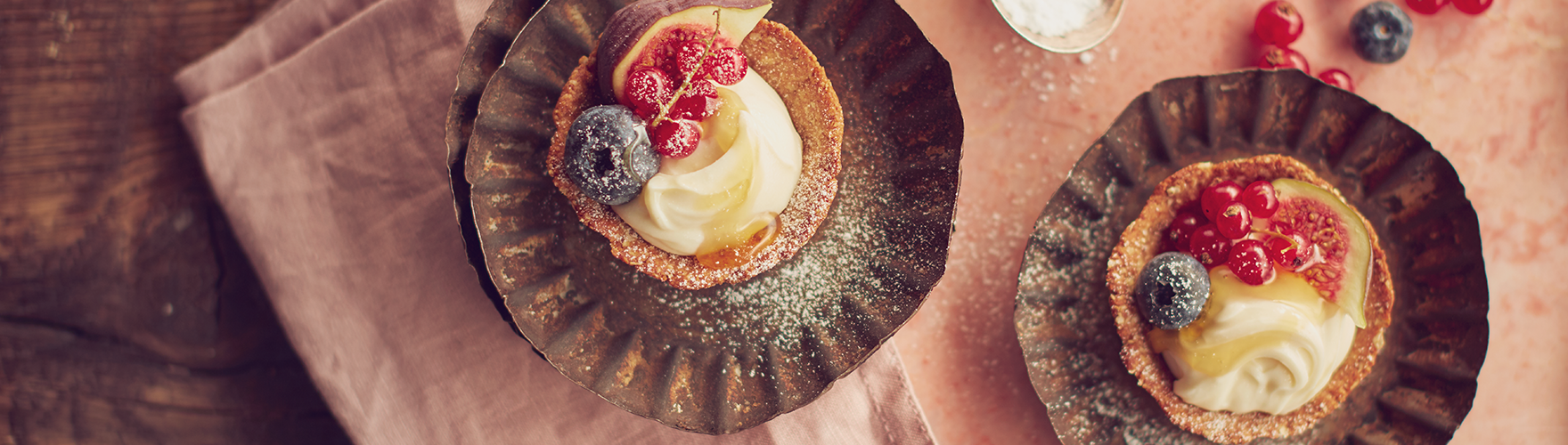 Granola taartjes met een mengsel van geitenkaas, vers fruit en honing