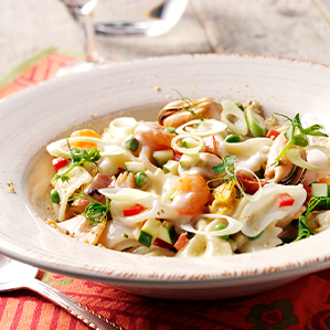 Farfalle met zeevruchten, paprika, courgette en een magere kaassaus