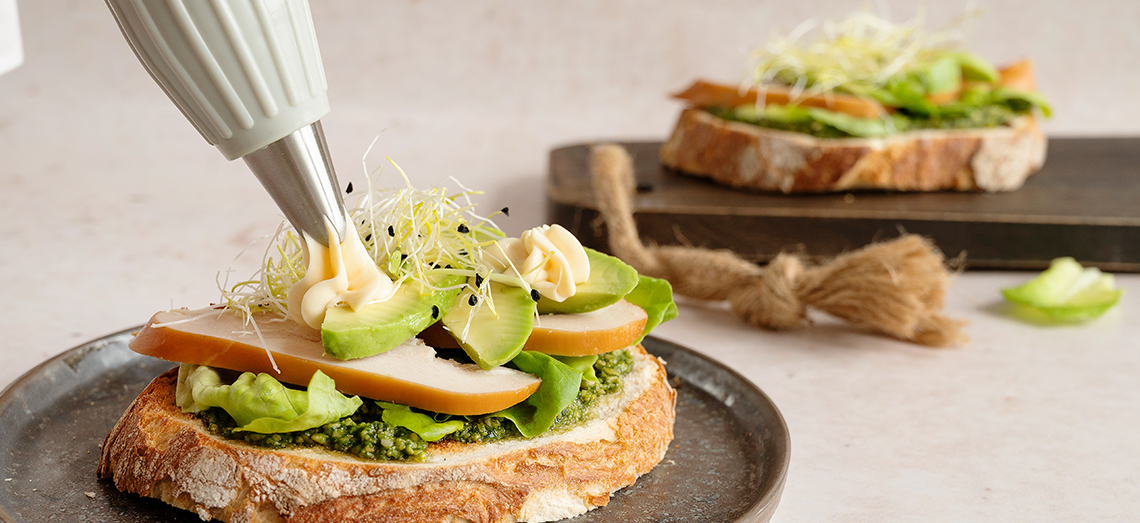 Zuurdesembroodje met gerookte kip, avocado, gerijpte kaas en kiemgroenten
