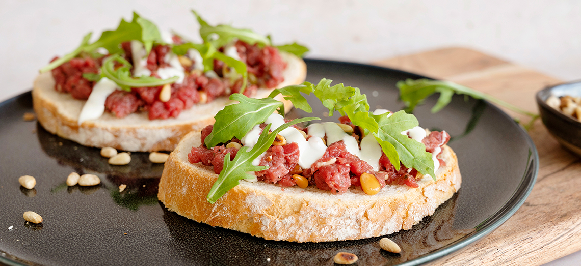 Zuurdesembrood met carpaccio filet, Parmezaanse kaas en pijnboompitjes