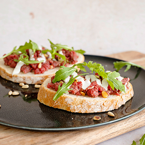 Zuurdesembrood met carpaccio filet, Parmezaanse kaas en pijnboompitjes